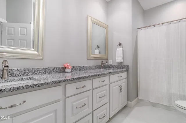a bedroom with a bed and flat tv screen on the dresser
