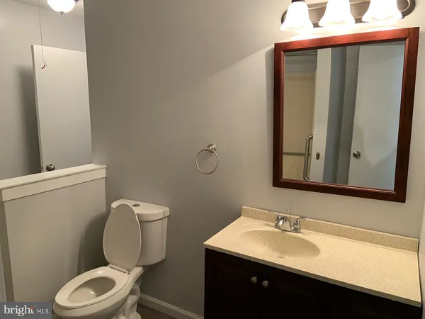a bathroom with a granite countertop toilet sink and mirror