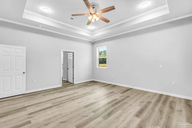 an empty room with windows and fan