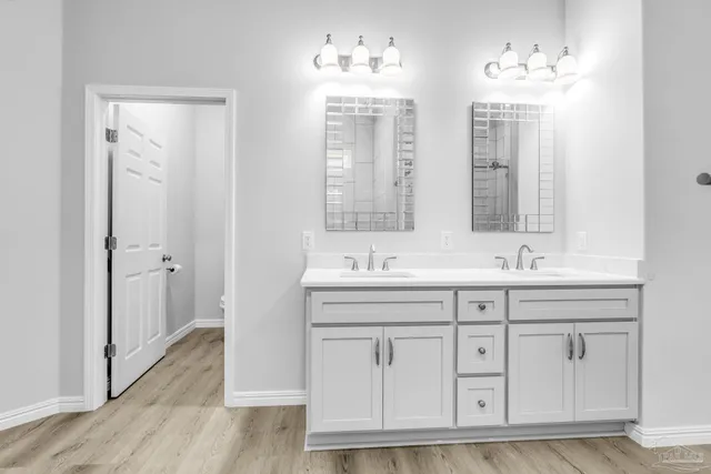 a bathroom with double vanity and a mirror