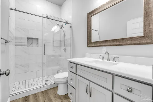 a bathroom with a sink a toilet and shower