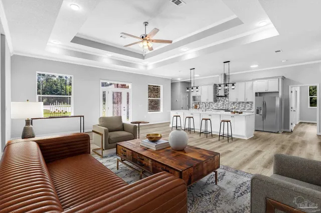 a living room with furniture kitchen view and a chandelier