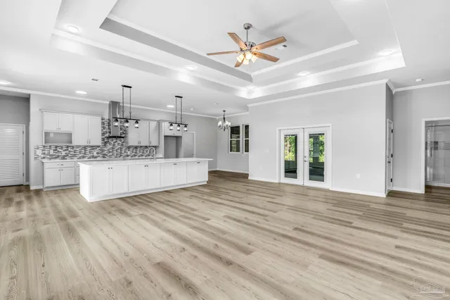 a view of large kitchen with a sink dishwasher a kitchen island with wooden floors and fireplace