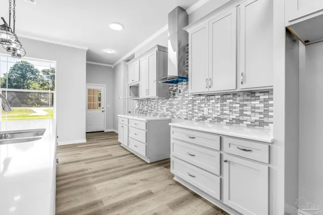 a kitchen with white cabinets and sink