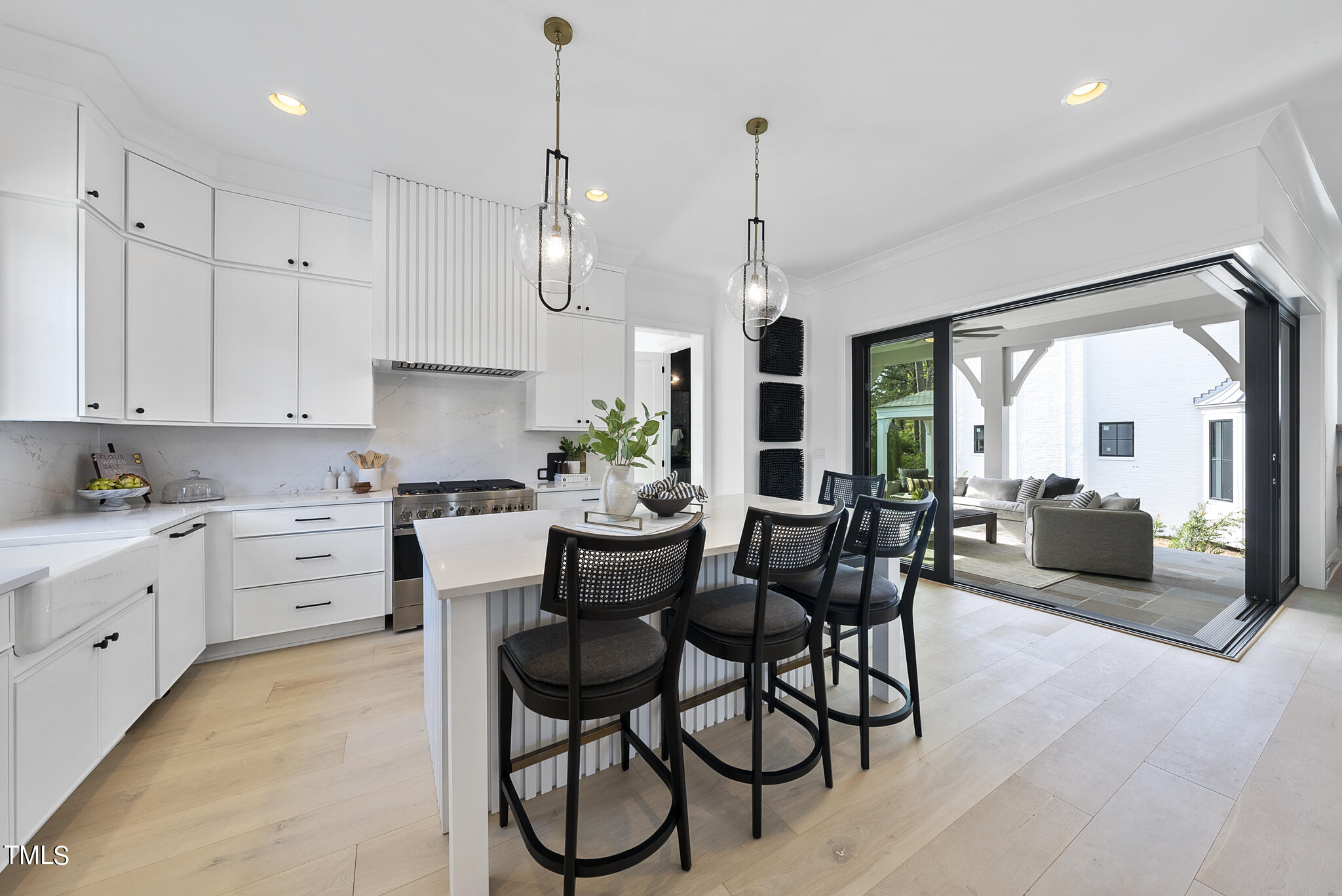 3305 Founding Place Raleigh, NC 27612 - Photo 46 of 100 a kitchen with stainless steel appliances kitchen island granite countertop a stove a refrigerator and white cabinets with wooden floor
