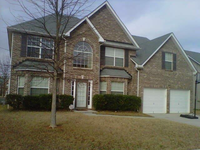 a front view of a house with a yard and garage