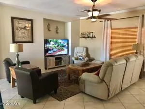 a living room with furniture a window and a flat screen tv