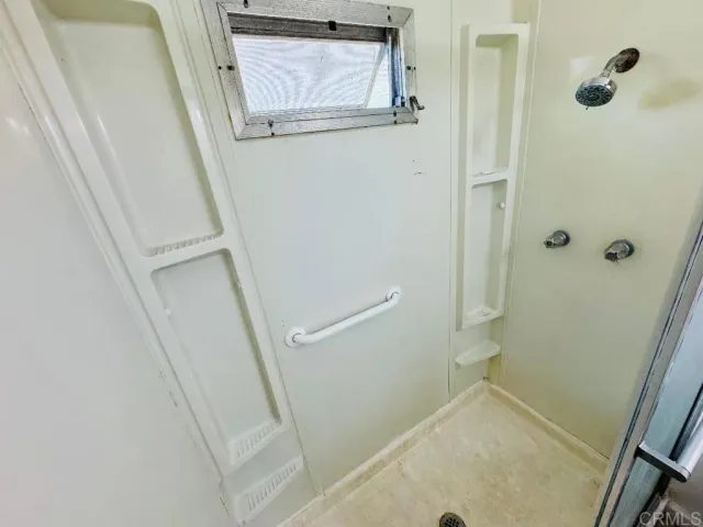 a bathroom with a shower and mirror