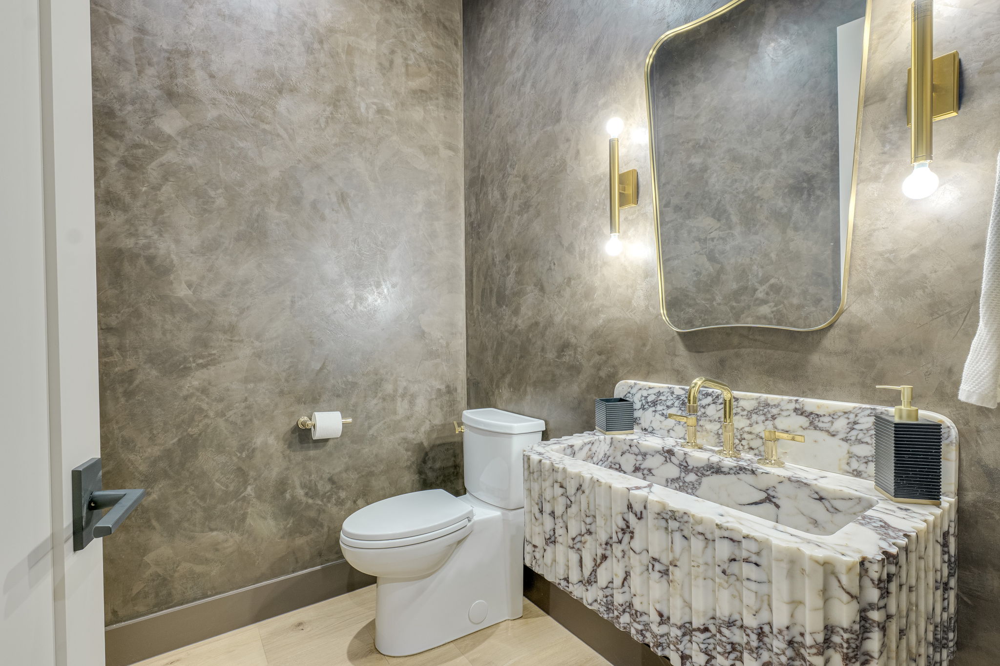 405 Honeycomb Ridge Austin, TX 78746 - Photo 8 of 15 Marble vanity and gilded fixtures elevate this chic bathroom's aesthetic.