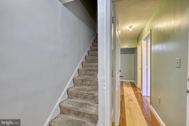 a view of a hallway with wooden floor and stairs
