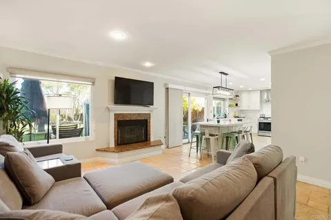 a living room with furniture a fireplace and a large window