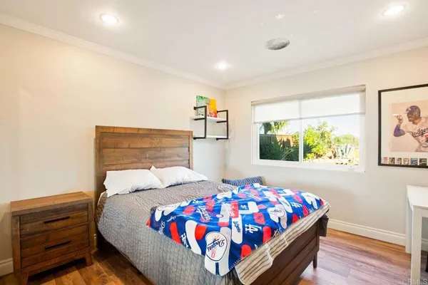 a bedroom with a bed and wooden floor