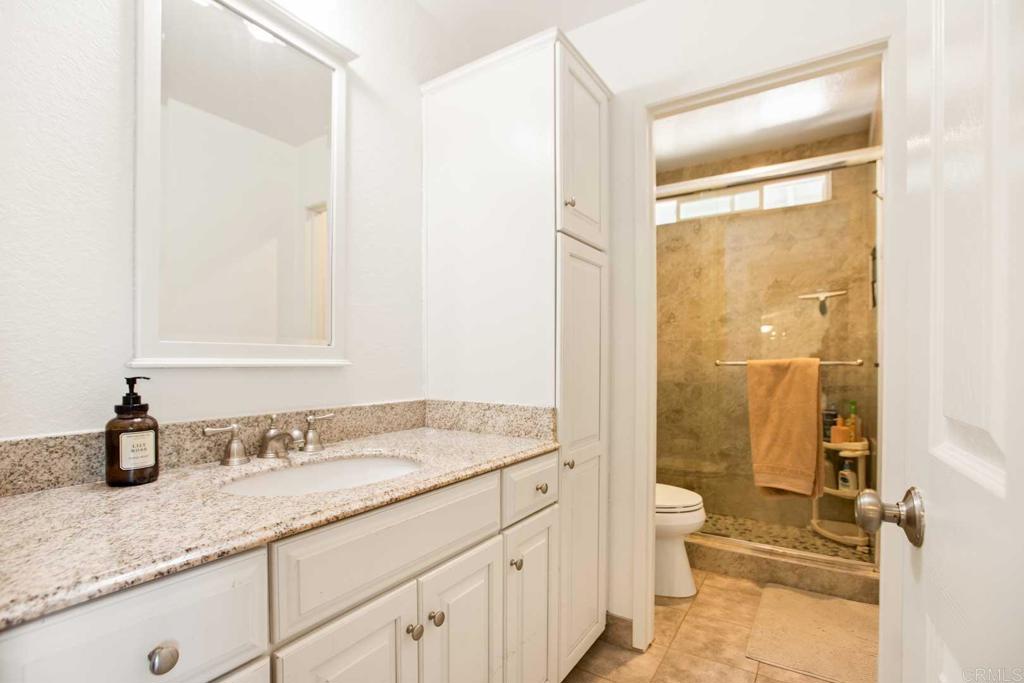 381 Via Almansa Encinitas, CA 92024 - Photo 26 of 32 a bathroom with a granite countertop sink mirror vanity and toilet