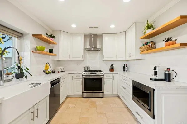a kitchen with cabinets a sink and white stainless steel appliances
