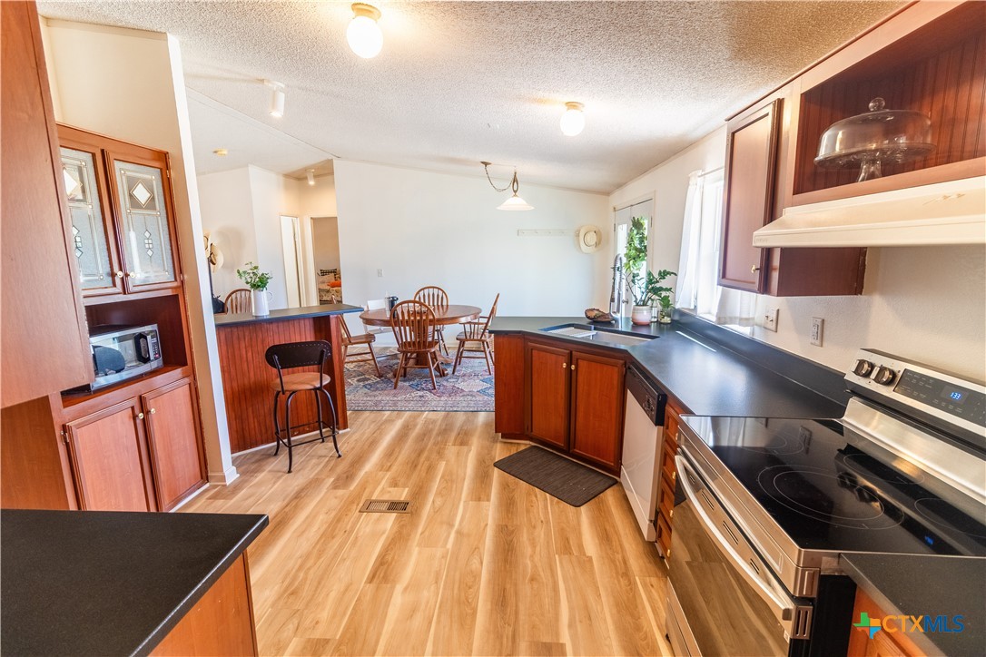 250 Rocky Road Lockhart, TX 78644 - Photo 15 of 45 a kitchen with stainless steel appliances a stove a sink a refrigerator cabinets and dining table