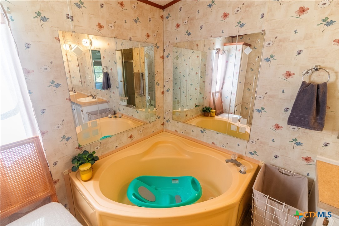 250 Rocky Road Lockhart, TX 78644 - Photo 25 of 45 a bathroom with a tub sink and mirror