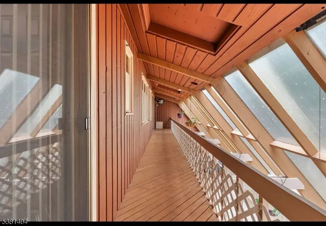 a view of an empty room with wooden floor and workspace