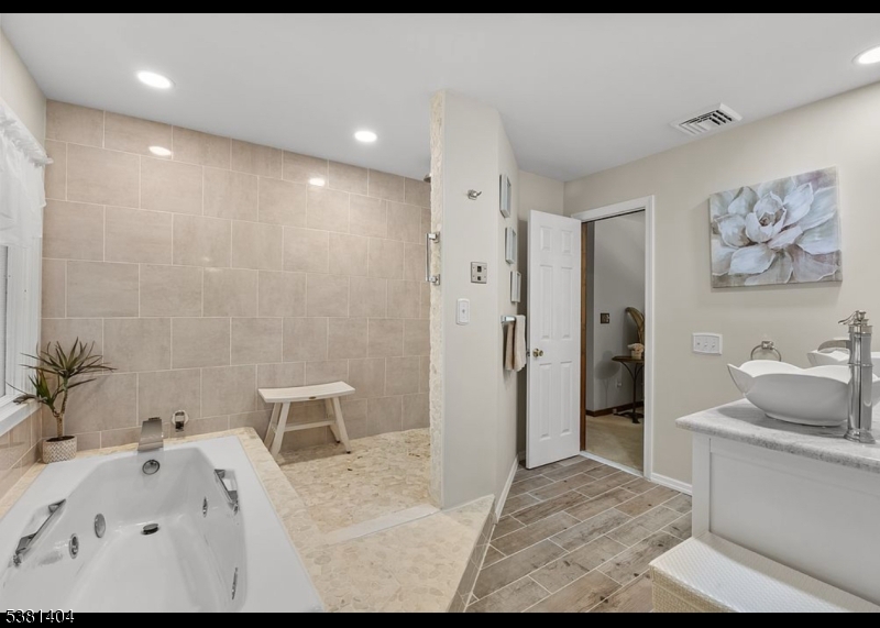 56 Sleepy Hollow Road Andover, NJ 07821 - Photo 32 of 37 a bathroom with a tub sink and mirror