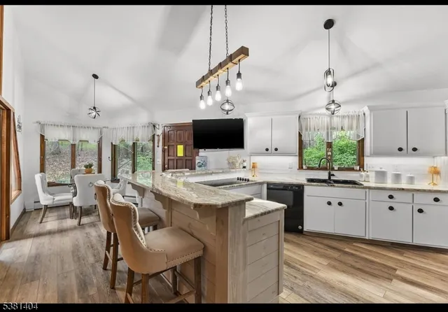 a kitchen with granite countertop a sink a counter space and cabinets