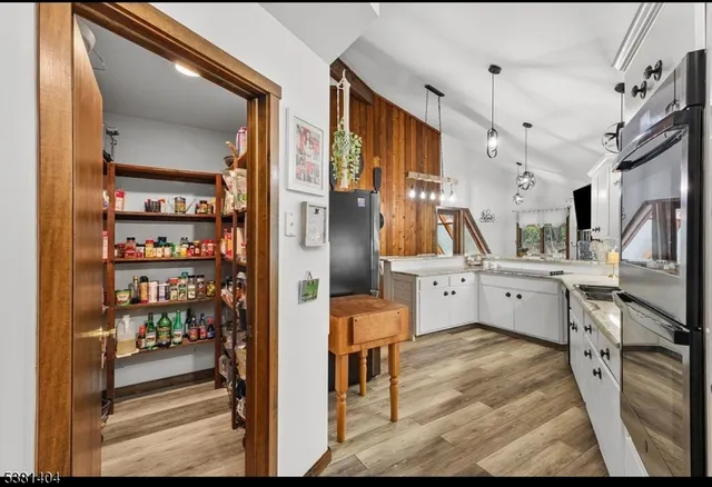 a large kitchen with granite countertop a white sink and cabinets