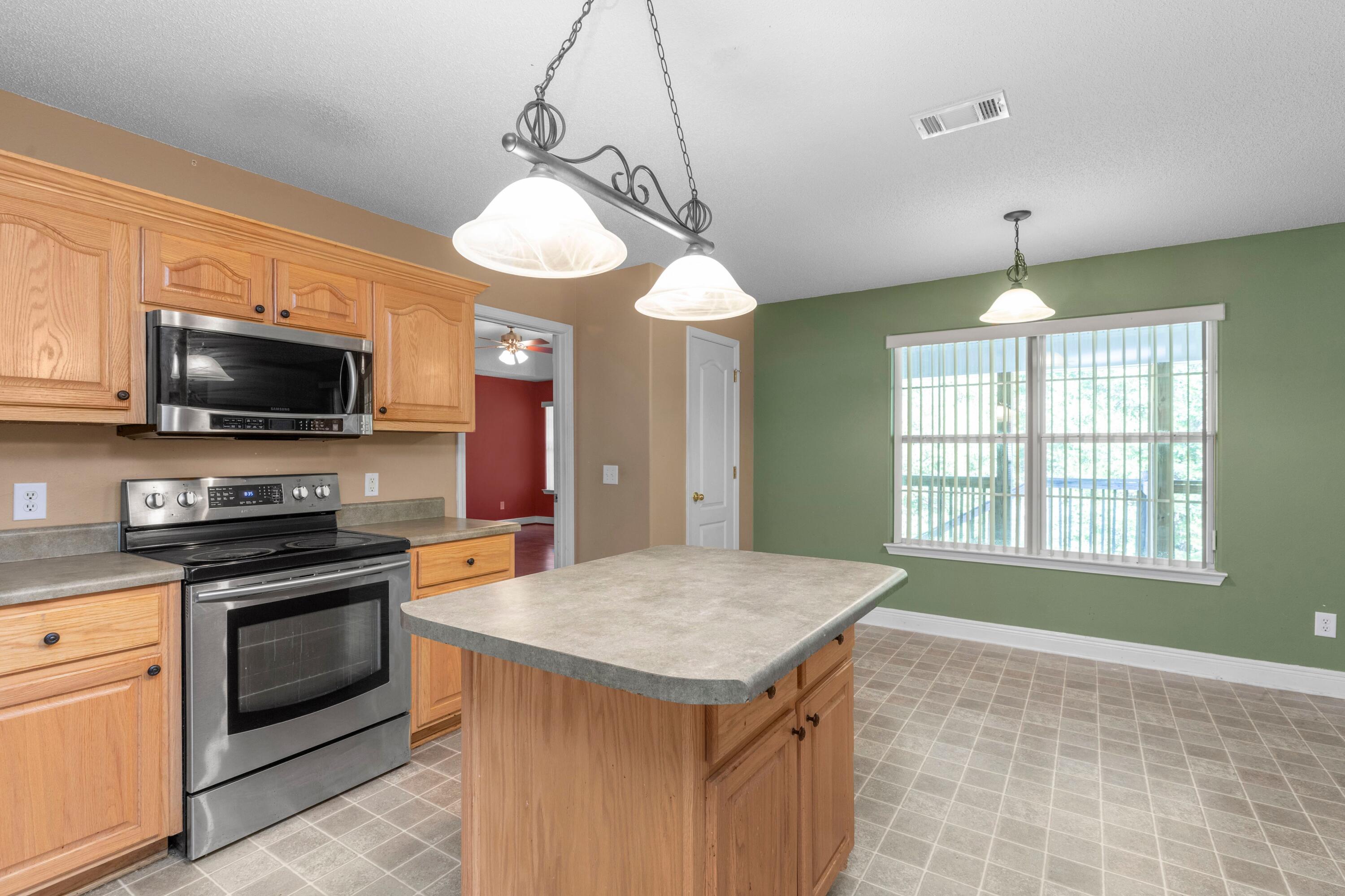 238 Foxchase Way Crestview, FL 32536 - Photo 10 of 33 a kitchen with a stove a sink and a window