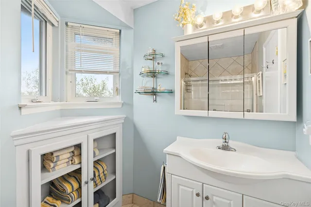 a bathroom with a sink a vanity and a window