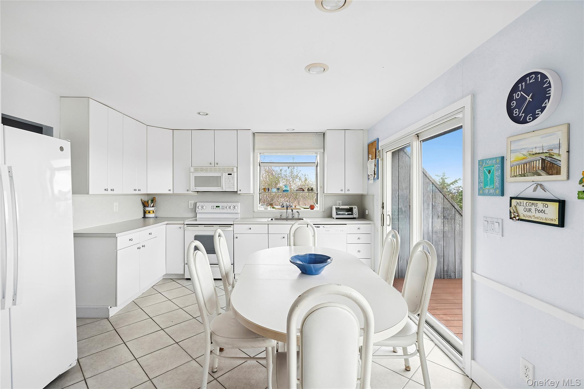 542 Dune Road Westhampton, NY 11978 - Photo 6 of 19 a kitchen with white cabinets and stainless steel appliances
