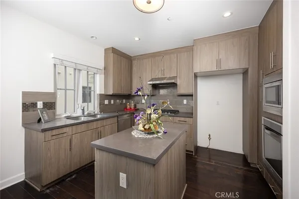 a kitchen with kitchen island white cabinets and stainless steel appliances