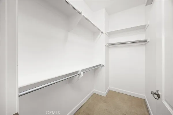 a view of an empty room with window and bathroom