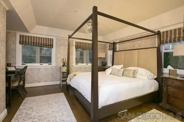 a bedroom with a bed table and window