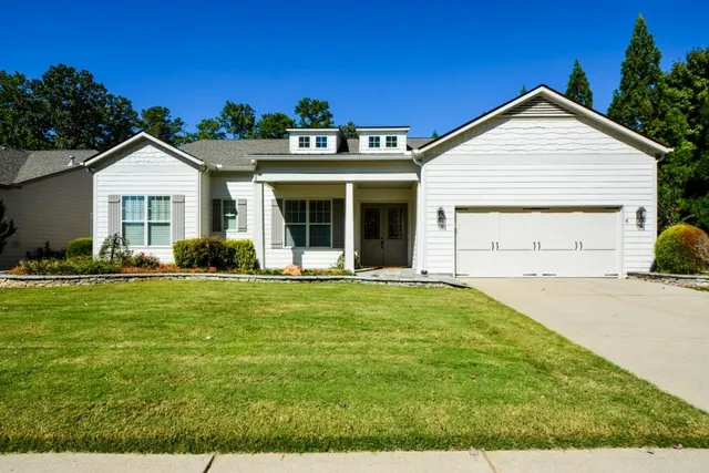 a front view of a house with garden and porch