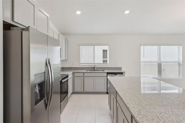 a kitchen with stainless steel appliances granite countertop a refrigerator and a sink