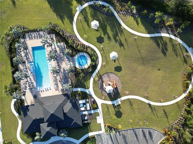 a swimming pool with outdoor seating and a garden