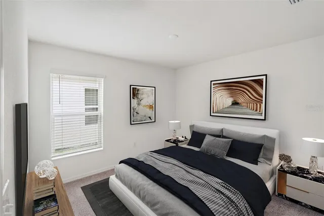 a bedroom with a bed and a painting on the wall