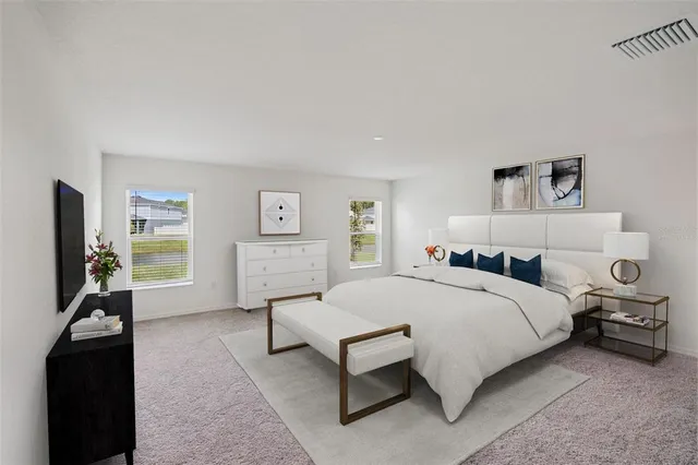 a bedroom with a bed and a flat tv screen on the dresser