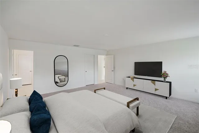a living room with a bed furniture and a flat screen tv