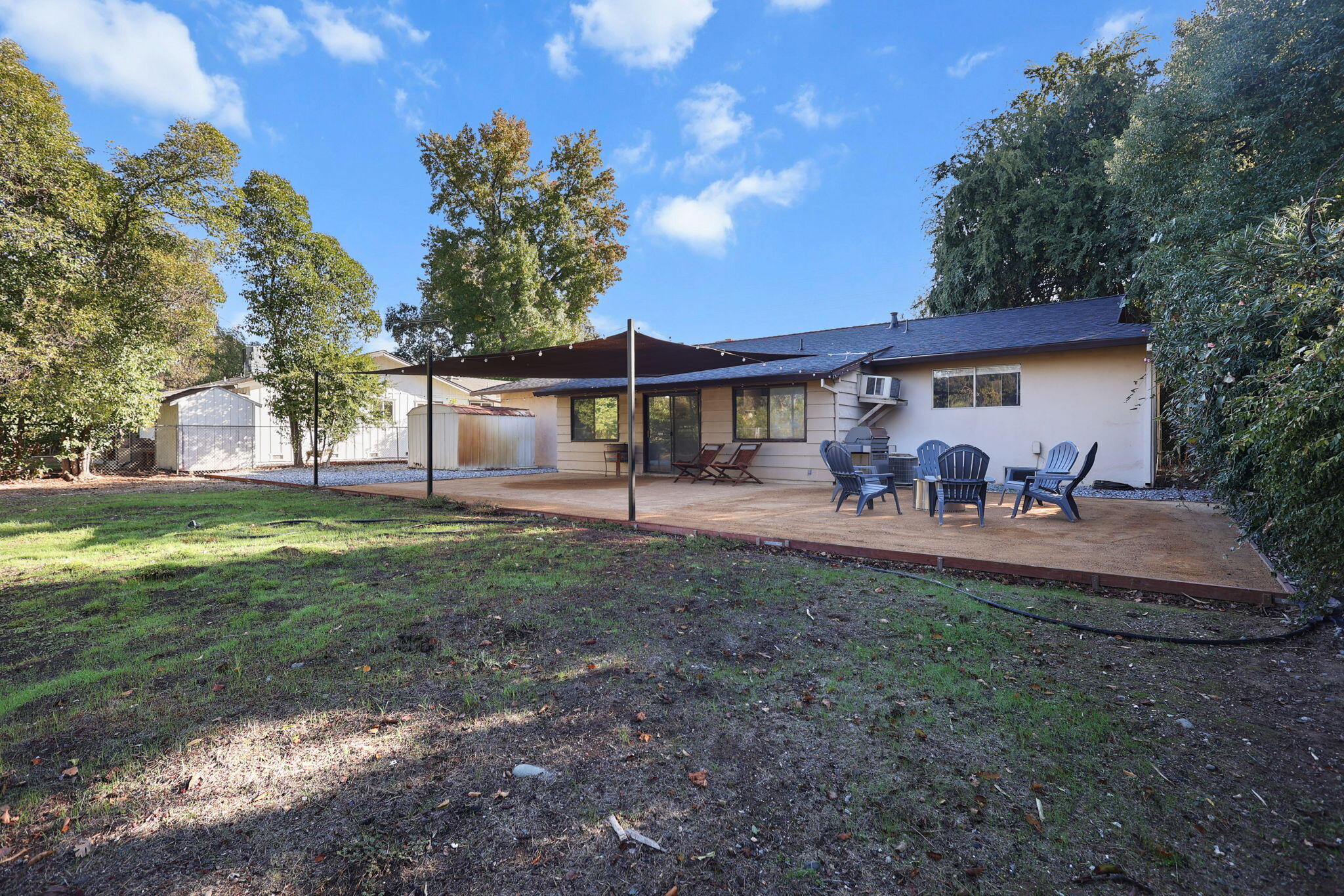 6958 Riverside Drive Redding, CA 96001 - Photo 25 of 30 a view of a patio with couches and table and chairs under an umbrella