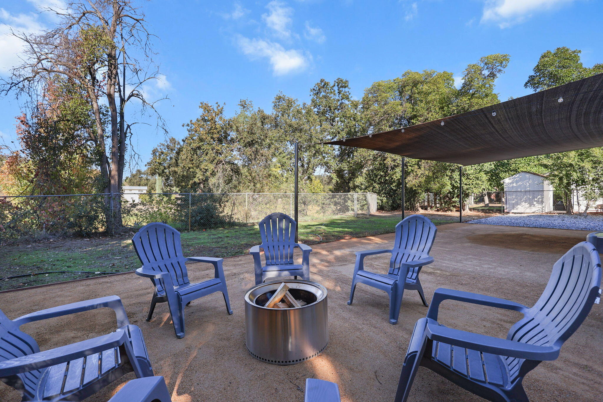 6958 Riverside Drive Redding, CA 96001 - Photo 26 of 30 a view of a patio with a table chairs and a fire pit