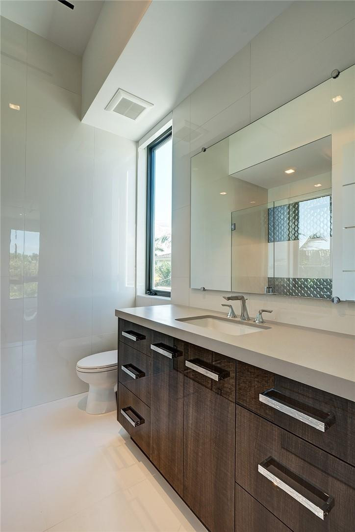424 Northeast 5th Street Boca Raton, FL 33432 - Photo 35 of 51 a bathroom with a sink a toilet a mirror and a window