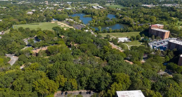 an aerial view of residential house with outdoor space and trees all around