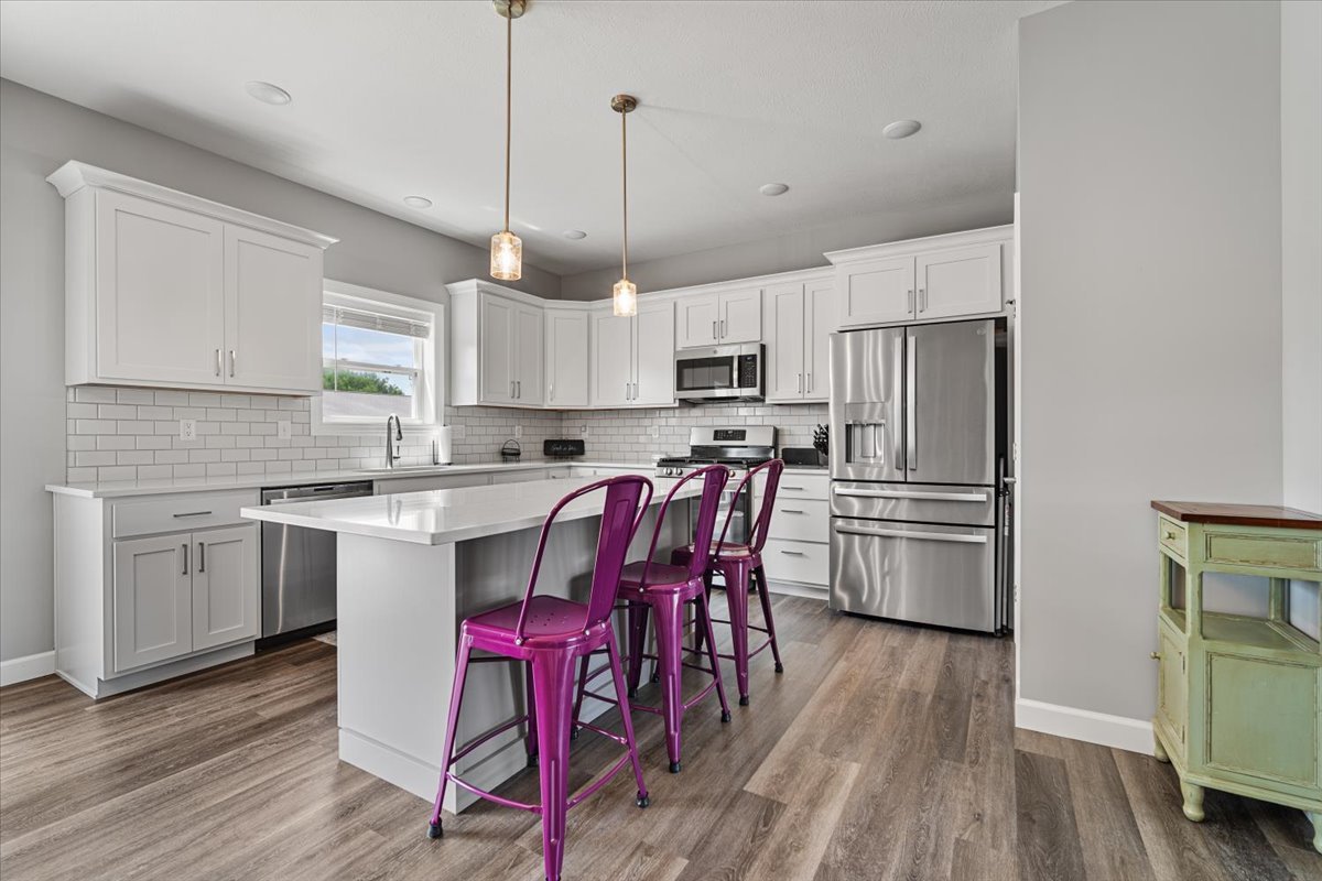 507 Raef Road Downs, IL 61736 - Photo 11 of 37 a kitchen with stainless steel appliances a microwave a stove a sink dishwasher a refrigerator with white cabinets and wooden floor