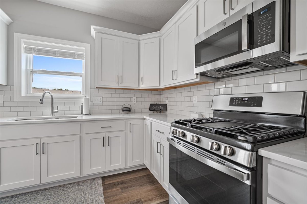 507 Raef Road Downs, IL 61736 - Photo 12 of 37 a kitchen with stainless steel appliances granite countertop a sink a stove and microwave