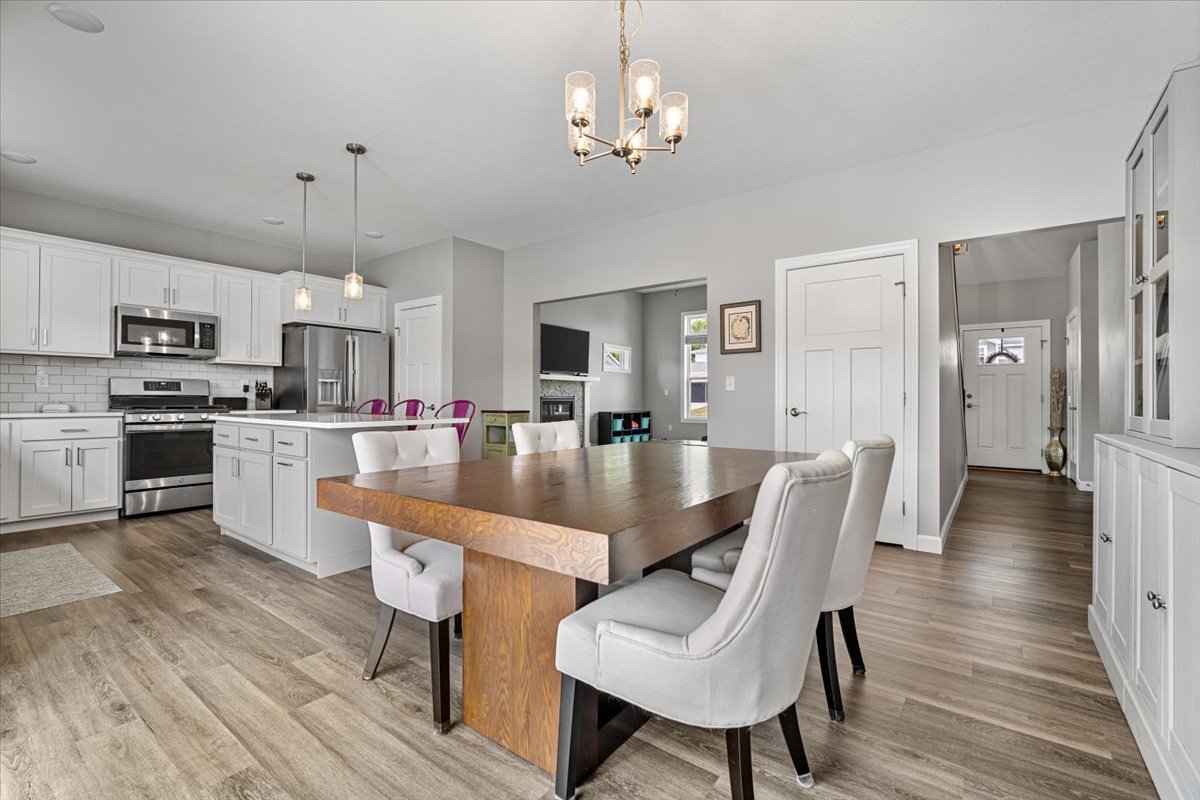 507 Raef Road Downs, IL 61736 - Photo 15 of 37 a kitchen with stainless steel appliances granite countertop a dining table chairs refrigerator and sink