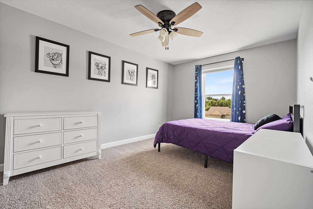 507 Raef Road Downs, IL 61736 - Photo 24 of 37 a bedroom with a bed a chandelier and a window