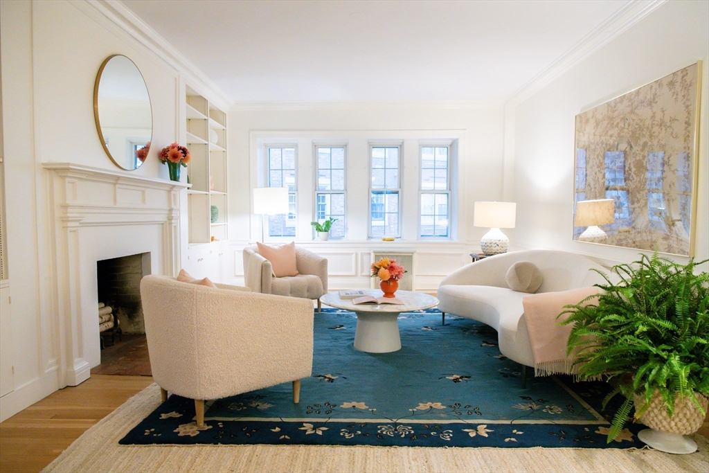 a living room with furniture a fireplace and potted plants
