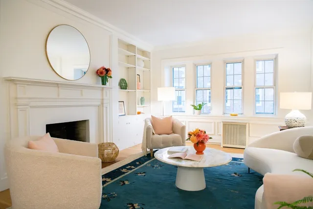 a living room with furniture a fireplace and a large window