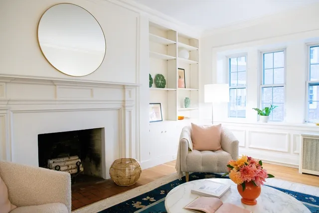 a living room with furniture a fireplace and wall paintings