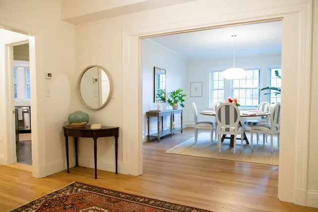 a dining room with furniture potted plants and wooden floor
