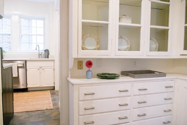 a kitchen with white cabinets and sink