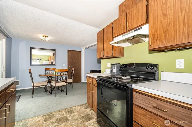 a kitchen with stainless steel appliances granite countertop a stove a sink dishwasher and cabinets